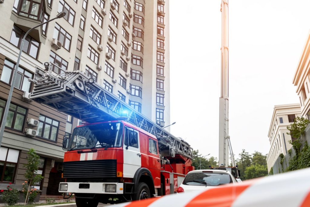 Fire engine with large ladder outside skyscraper