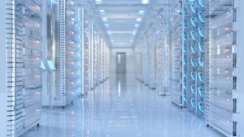 Racks of network servers and other computer hardware along a long white hallway