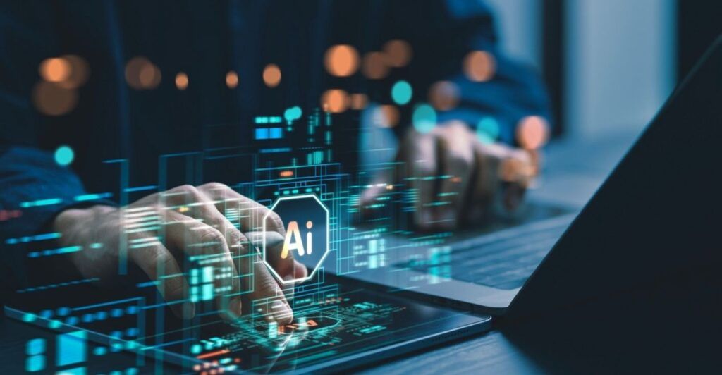 A hand typing on a laptop and a tablet at the same time with a holographic AI icon above.