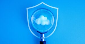 Une loupe examinant l'icône d'un nuage, avec un insigne de police en arrière-plan.