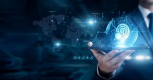 A hand holding a tablet with a 3D digital icons of a fingerprint, magnifying glass, and world map projected above it